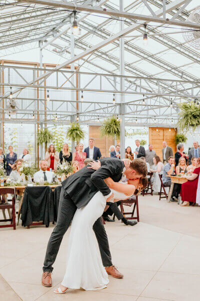 Bride and Groom dip and kiss inside The Atrium