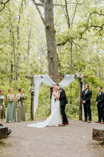 Bride and groom first kiss at outdoor wedding venue in Wisconsin
