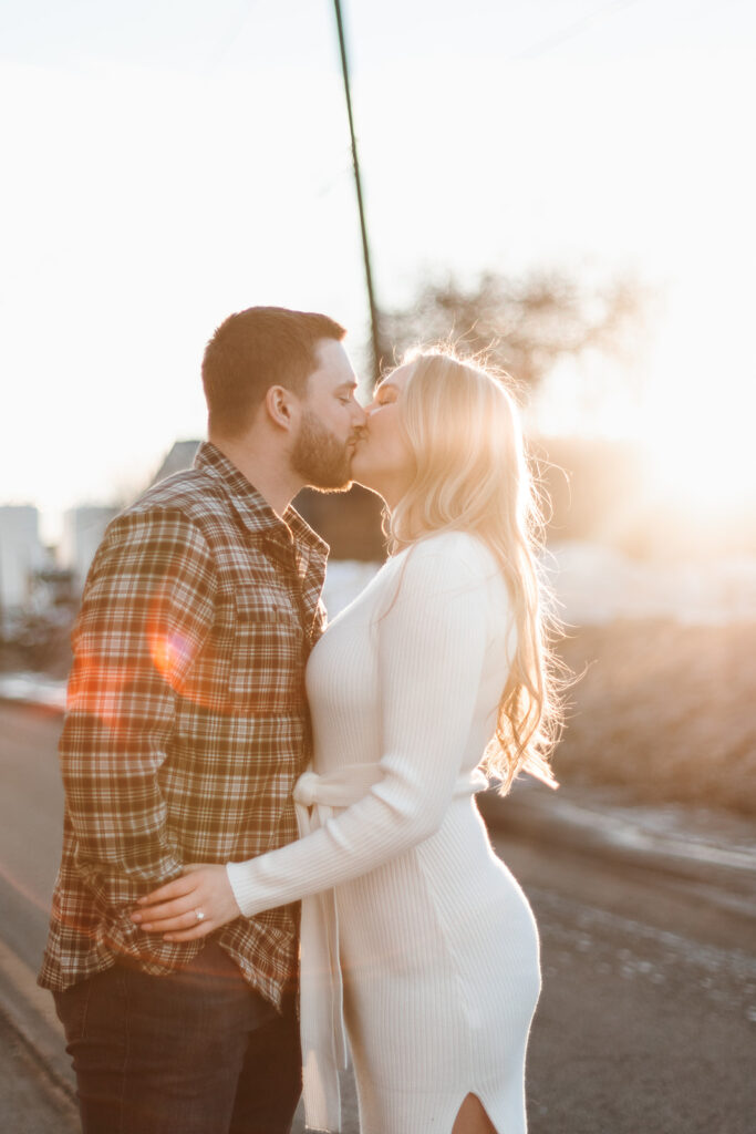 Sunset engagement photos of couple kissing in the street